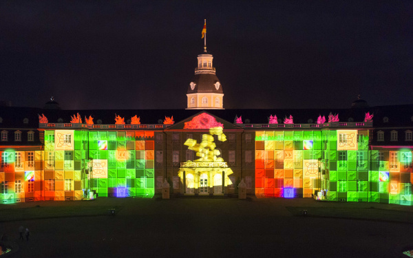 Eine goldene Pyramide und bunte Steine auf der Schlossfassade