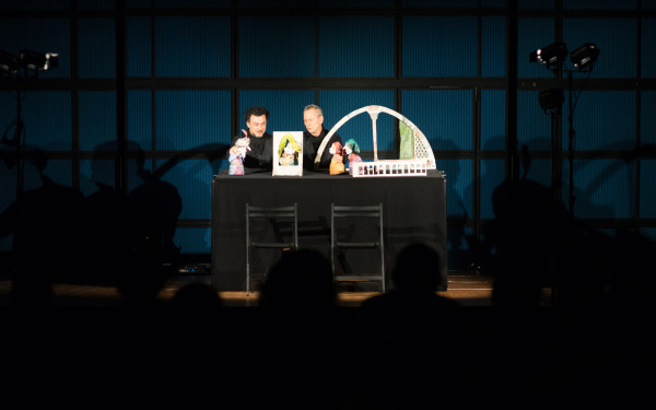 Two men play puppet theater