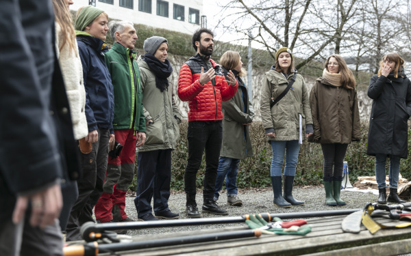 Eine Gruppe von Menschen stehen vor Gartenwerkzeugen im Rahmen des Baumschnitt-Kurses vom ZKM.
