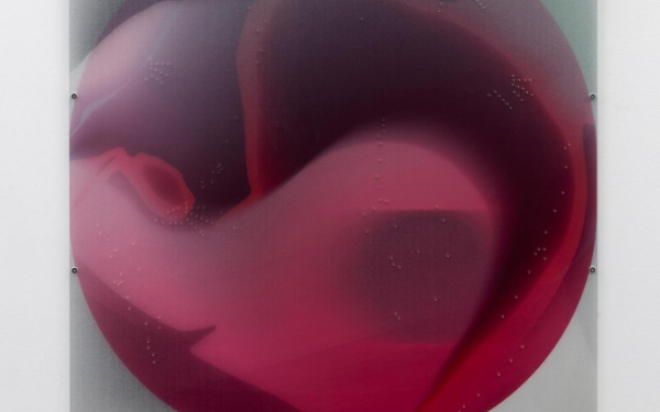 Round, red collage under plexiglass