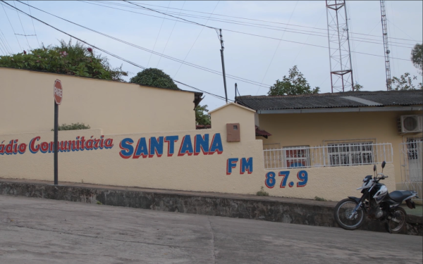You can see a wall of a house which says "Radio Comunitaria Santana FM 87.9".