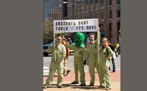 Four people are holding up a banner which says "Amazonia dont touch - its ours"