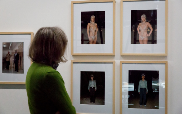Eine Frau blickt auf mehrere Fotografien