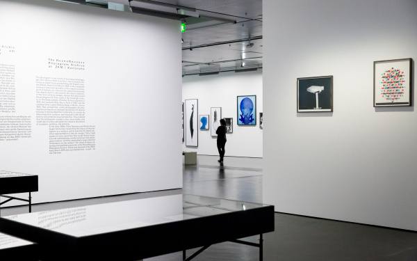 Blick in die Ausstellung »Leibniz' Lager«, in der eine Frau geht