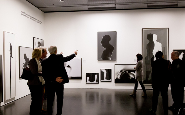 Mehrere Menschen laufen durch die Ausstellung »Leibniz' Lager«