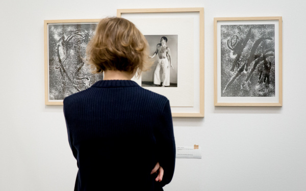 Eine Frau betrachtet verschiedene Fotografien