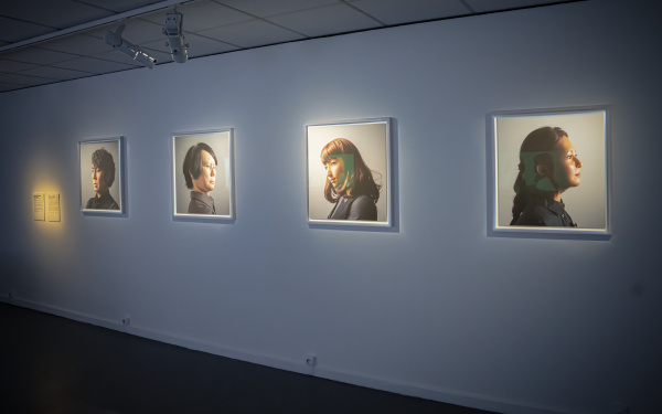 Maija Tammi, »One of Them Is a Human, #1-4«, 2017. Zu sehen sind vier Porträts, die unterschiedliche Menschen abbilden, an einer Wand. 
