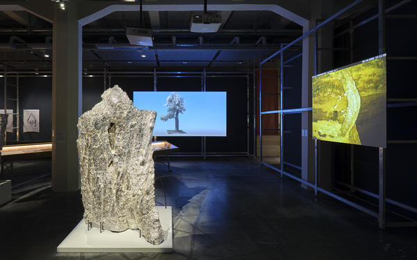 Zu sehen ist ein Ausstellungsraum mit zwei projizierten Bildern.