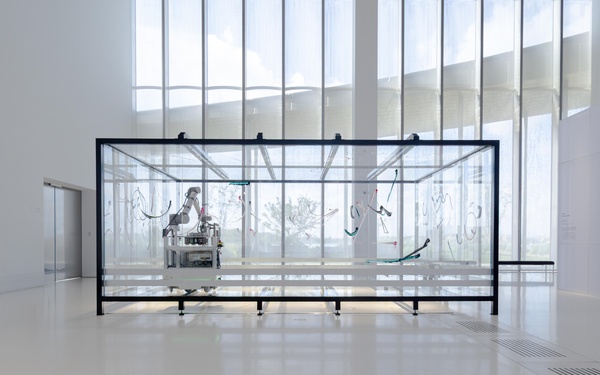 Ein Roboterarm in einem Glaskasten