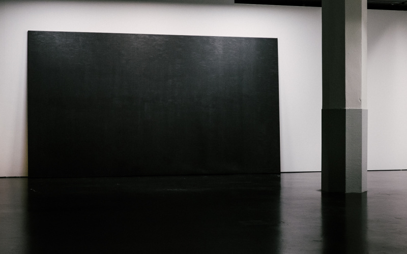 Eine schwarze Leinwand steht im Raum