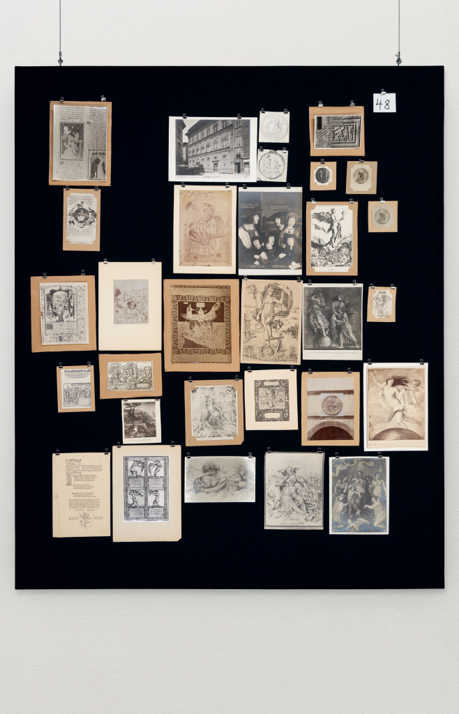 With black fabric-covered panel with image reproductions.