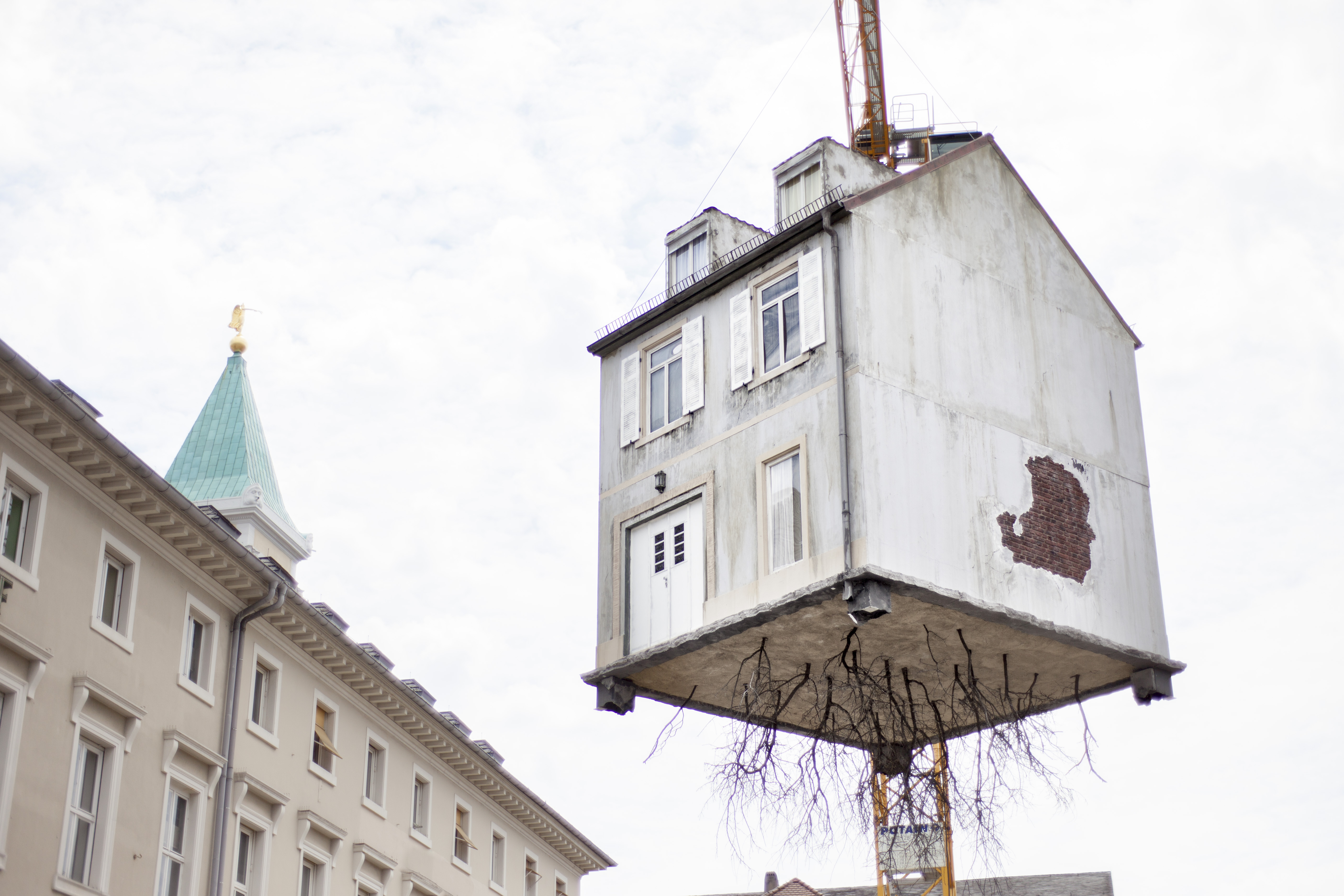 A house hangs on a crane