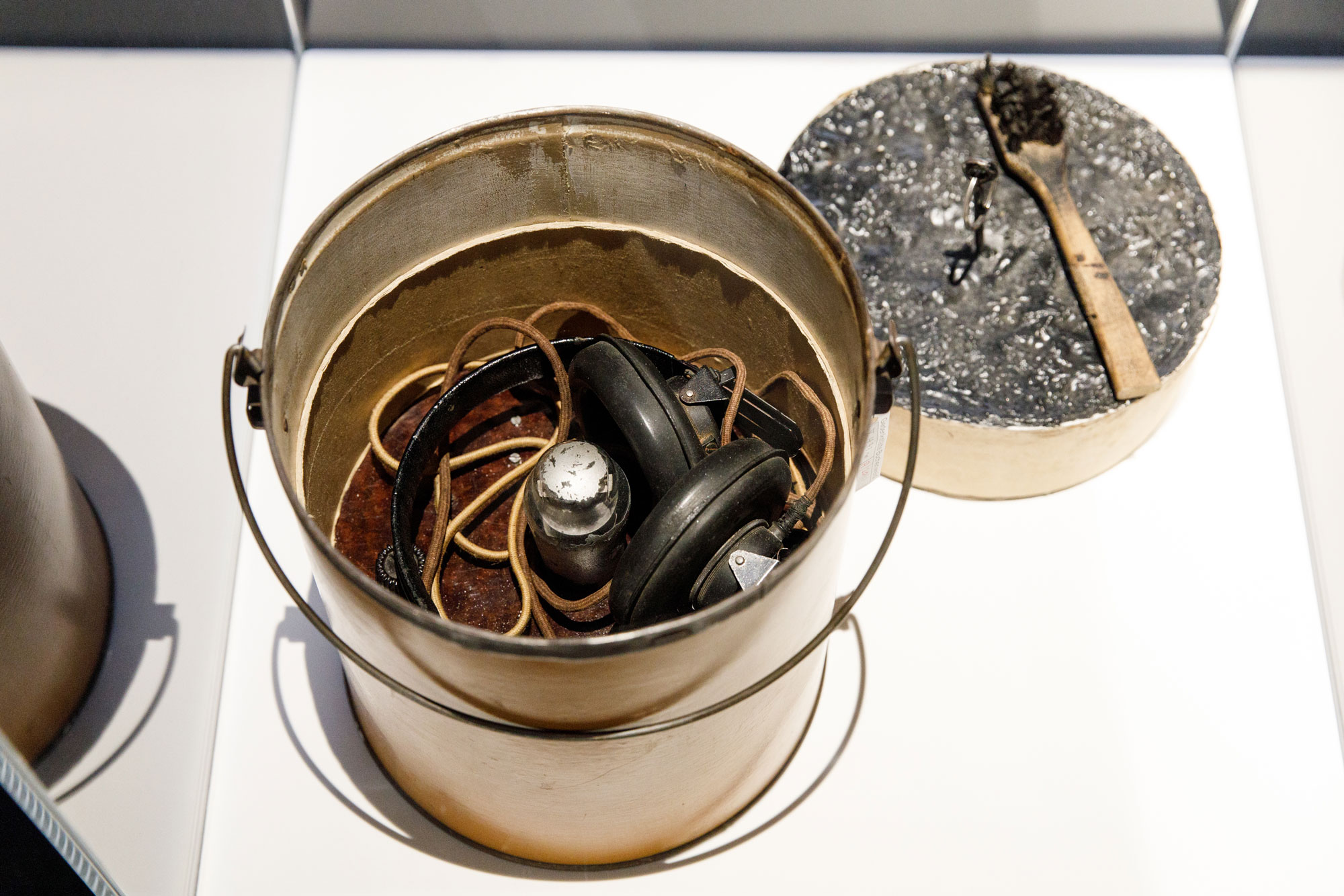 Metallener Eimer mit Kopfhörern und Kabeln