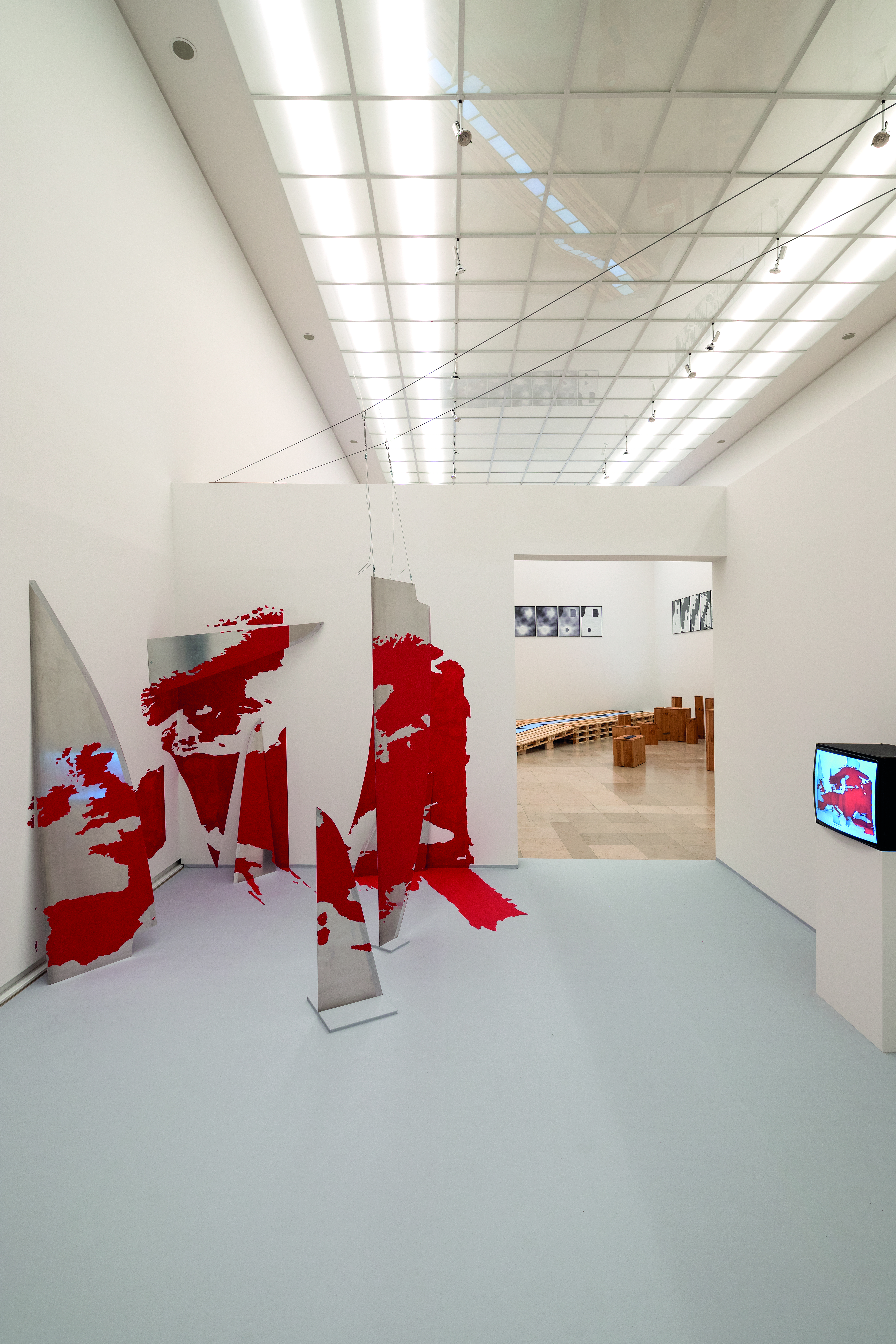 Installationsansicht. Im Raum ist eine Weltkarte dreidimensional in die Wand verwachsen. 