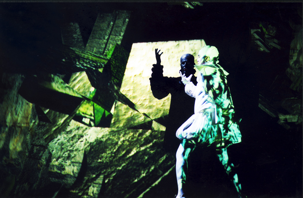 Two customed people dance in green light