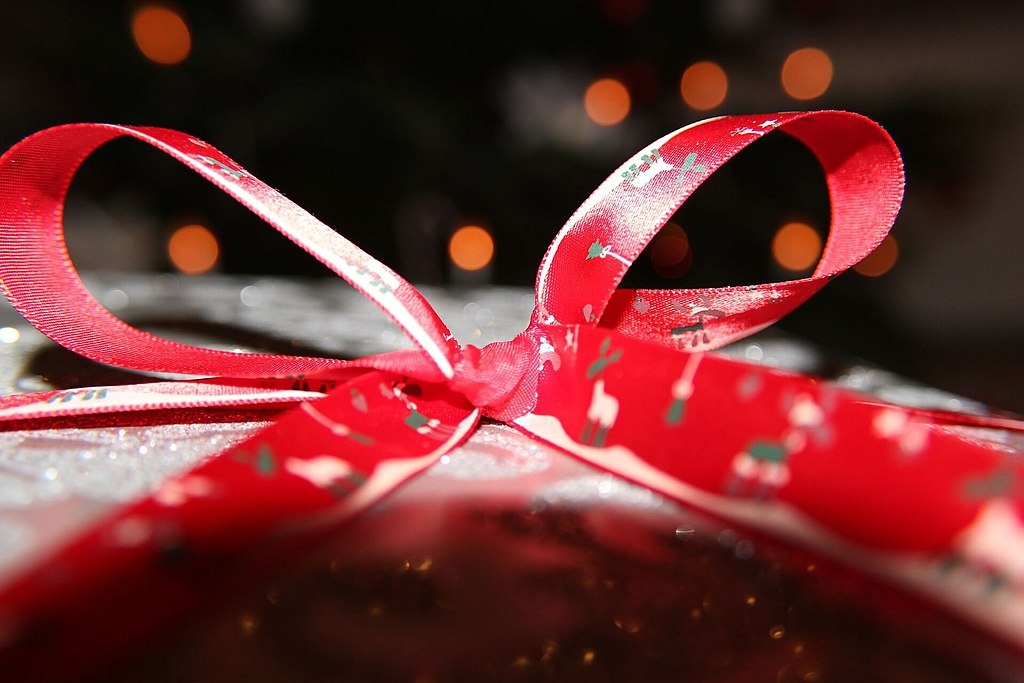 Foto eines Weihnachtsgeschenks mit roter Schleife. 
