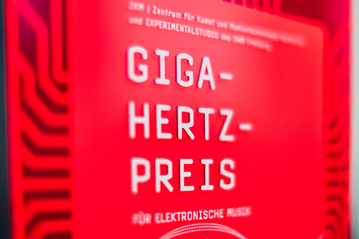 Roter Plakette, auf der mit weißer Schrift "Giga-Hertz-Preis" steht