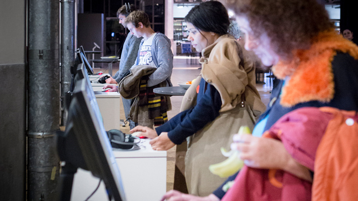 Several People standing in front of computer stations