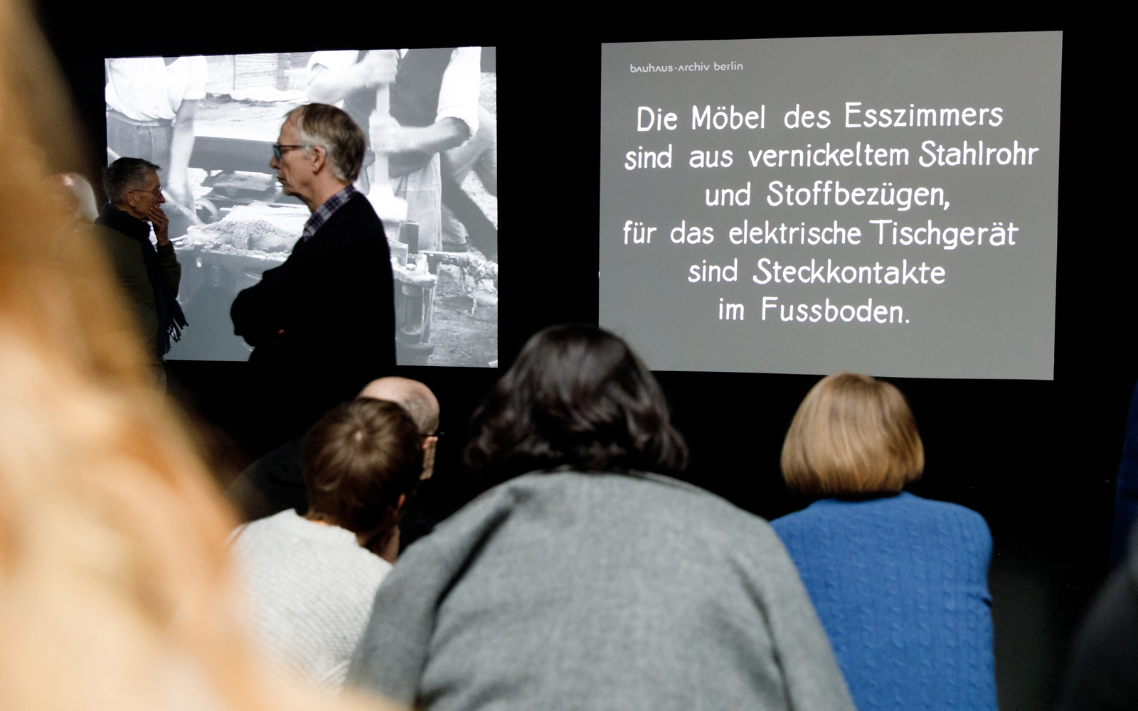 Eine dunkle Leinwand auf der ein schwarzer Text zu sehen ist.