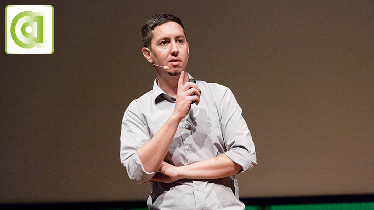 A man is standing on a stage giving a speach