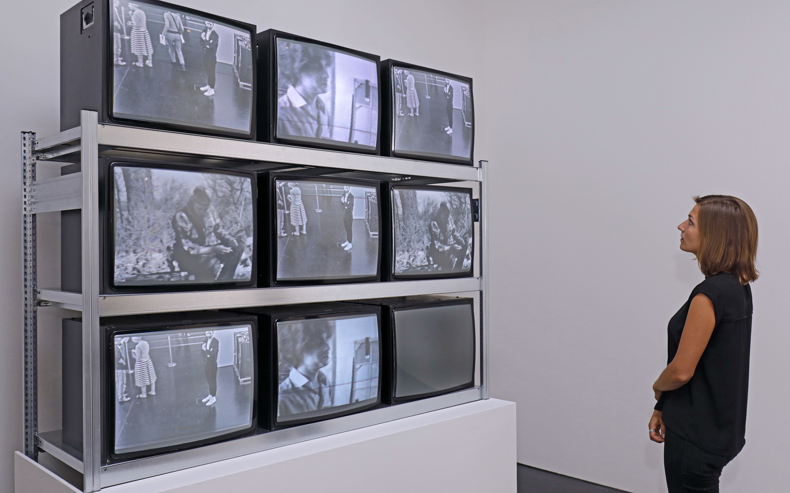 Visitor in front of an installation consisting of nine TV screens