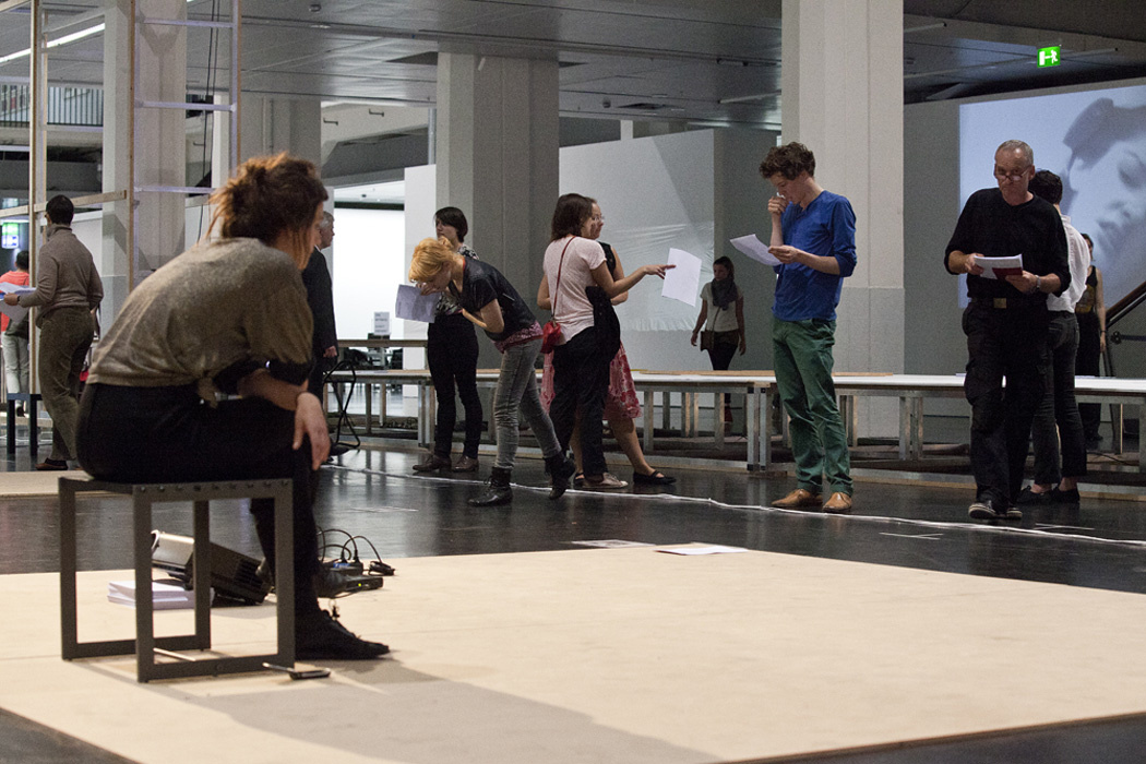 mehrere Personen im Ausstellungsraum, die Texte üben