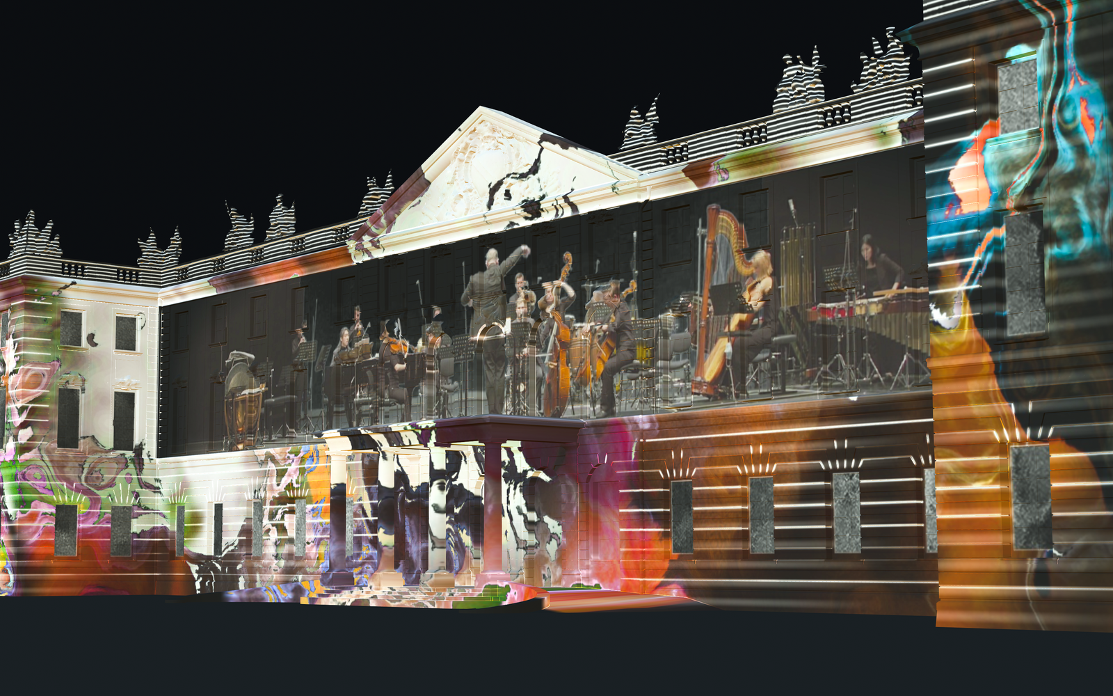 Auf der Karlsruher Schlossfassade ist ein Projection Mapping zu sehen, das in der Nacht leuchtet. Das Mapping zeigt bunte Farbwirbel, in deren Mitte ein Orchester spielt.