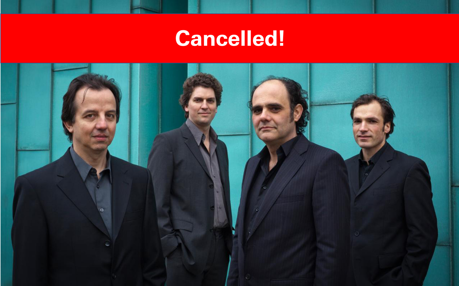 The four men of Aleph guitar quartet behind a turquoise background