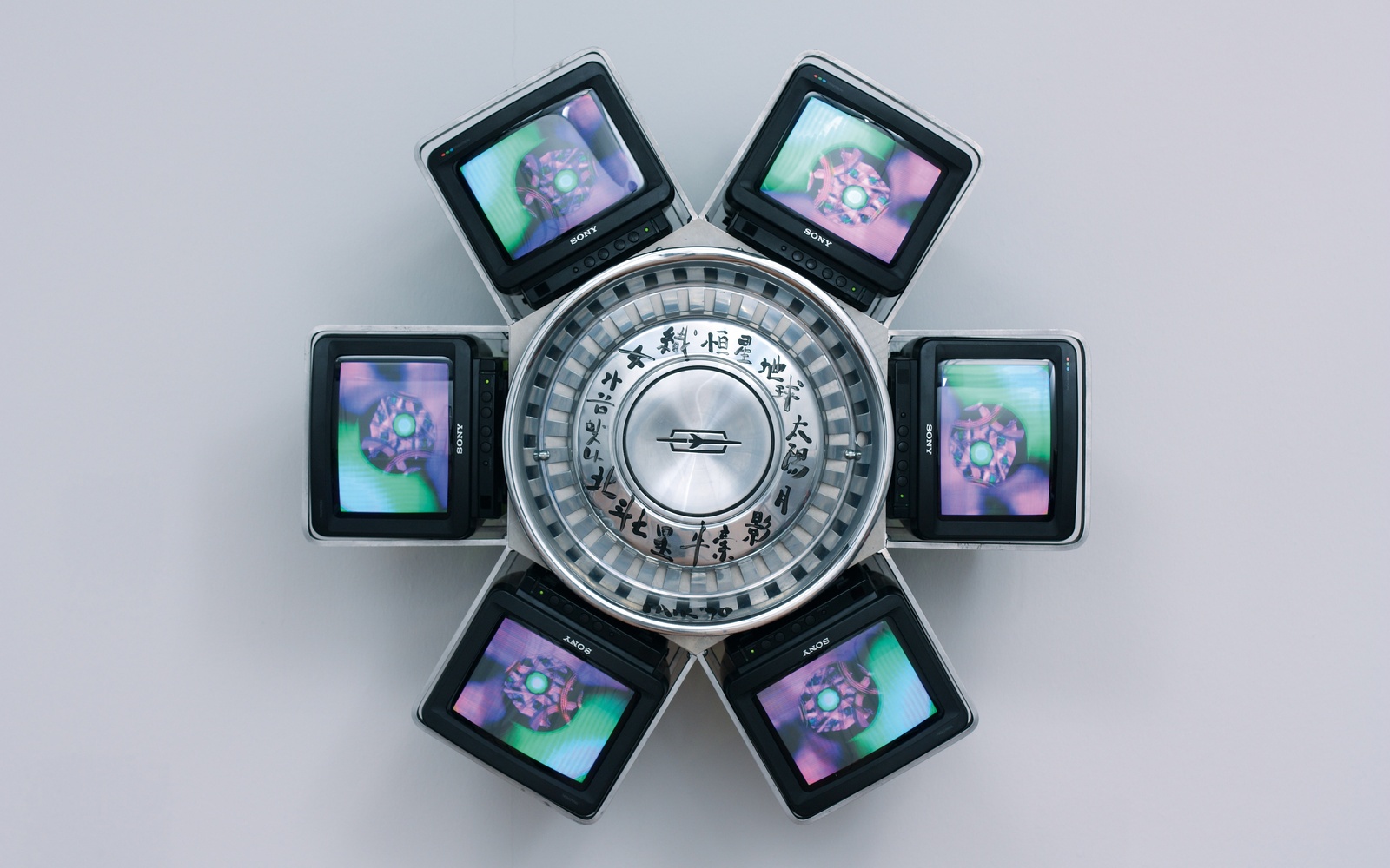 Zu sehen ist eine Videoskulptur, die sechs Monitore enthält. 