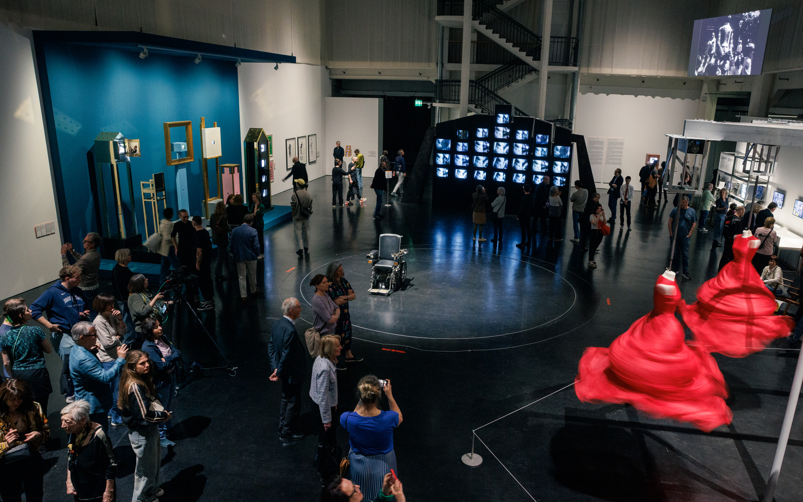 Das Foto zeigt einen mit Menschen und Exponaten gefüllten Ausstellungsraum. 