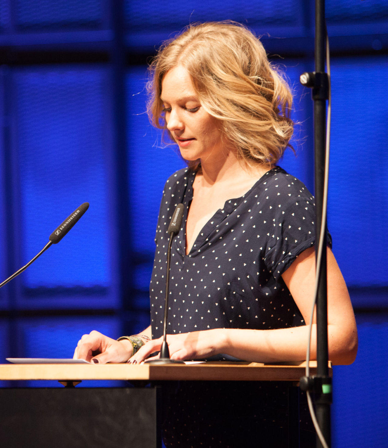 A woman standing at a table an reading something