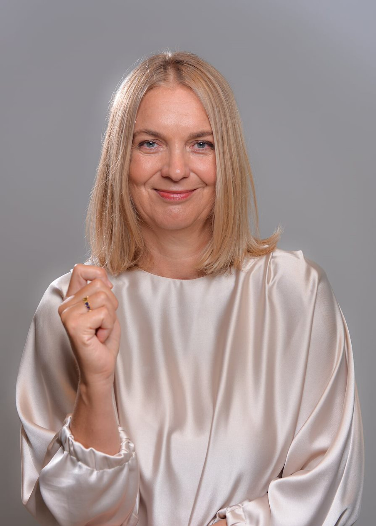 On display is a portrait of Regina Stober-Koop, the chairwoman of the sponsoring society. She has long blonde hair and wears a white blouse.