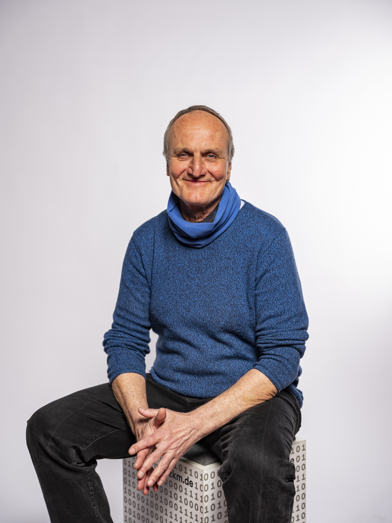sitzender Mann in blauem Pullover