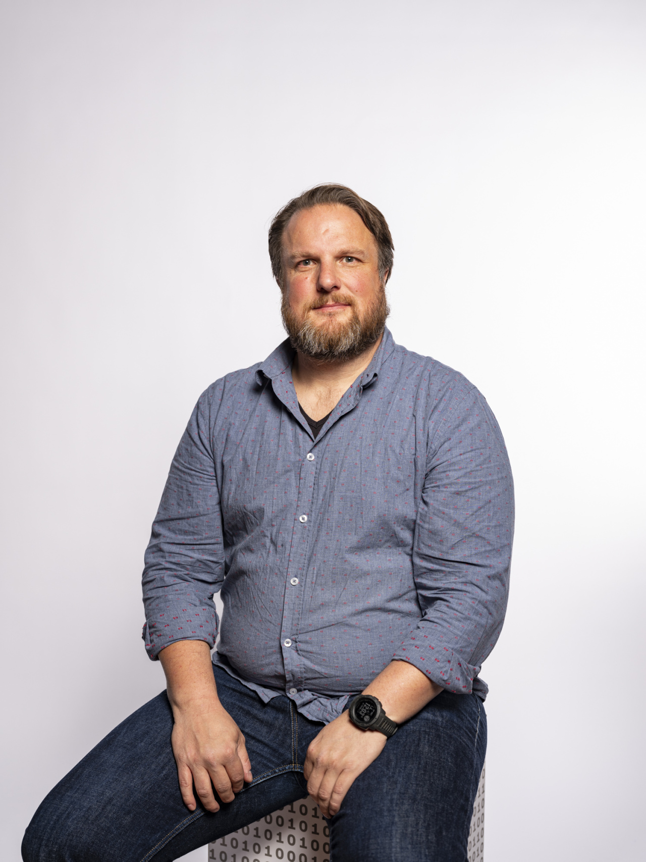 sitzender Mann in einem hellblauen Hemd