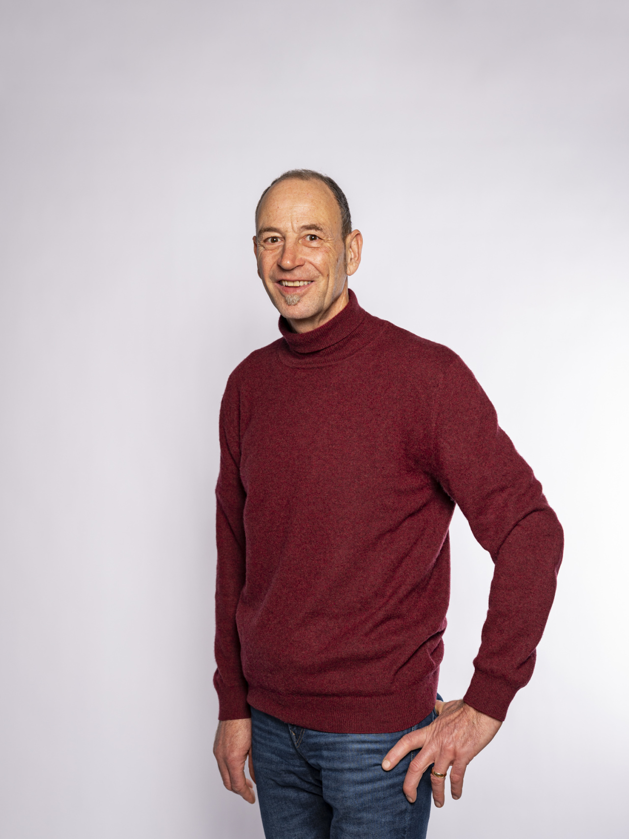 stehender Mann mit rotem Pullover
