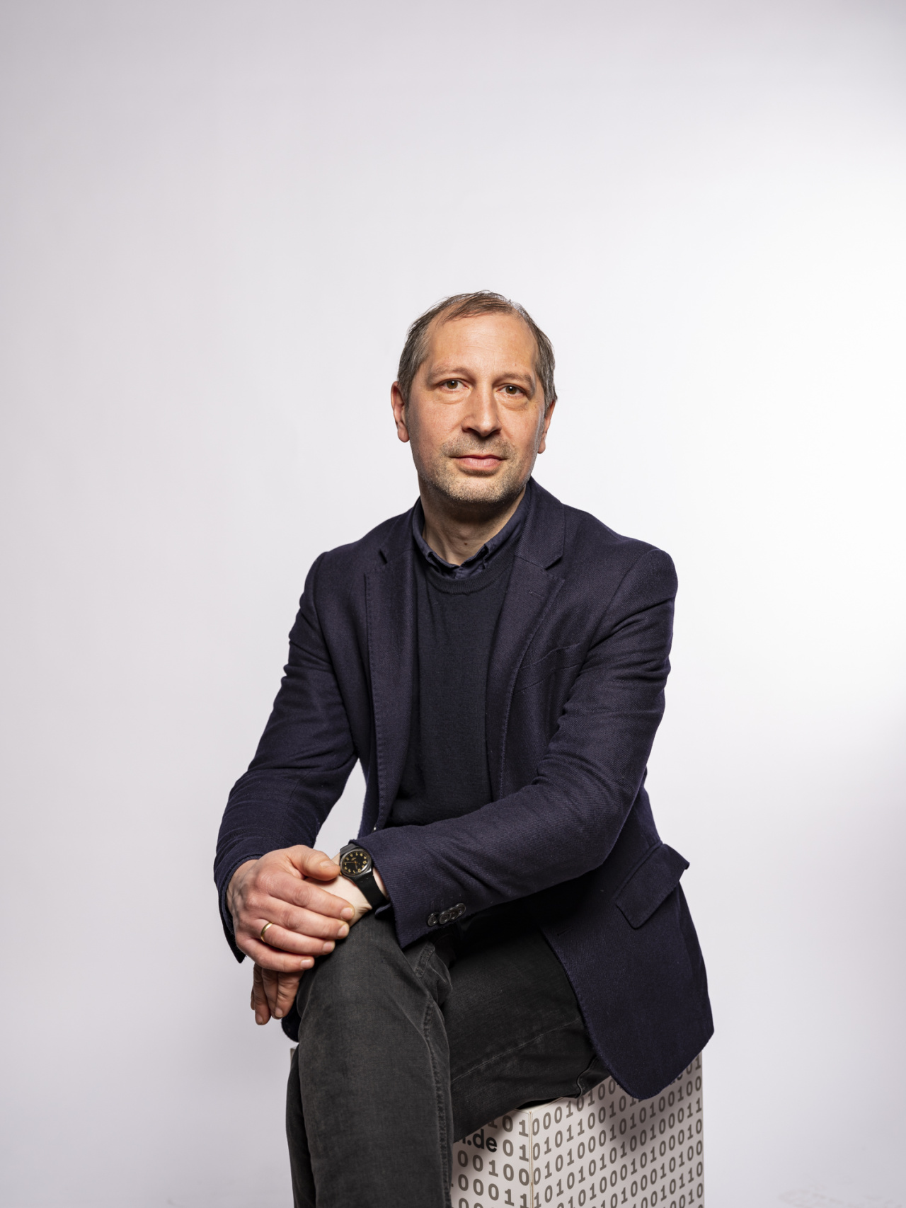 sitzender Mann mit blauem Jacket 