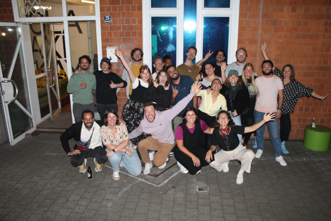 You can see a large group of young people standing in front of a brick house.