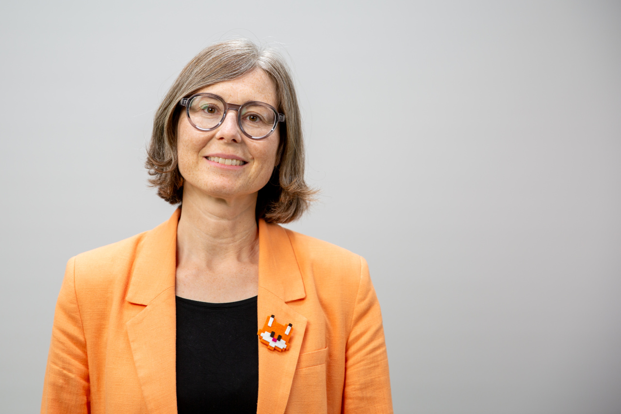 Sitzende Frau mit hellen Haaren und Brille