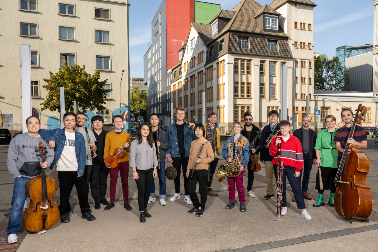 Zu sehen ist eine Gruppe von Personen mit verschiedenen Musikinstrumenten.