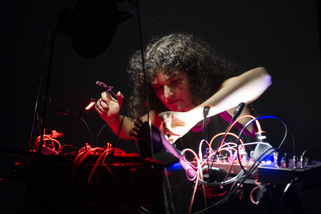 The picture shows a person holding an eyelash curler that is connected to a cable.