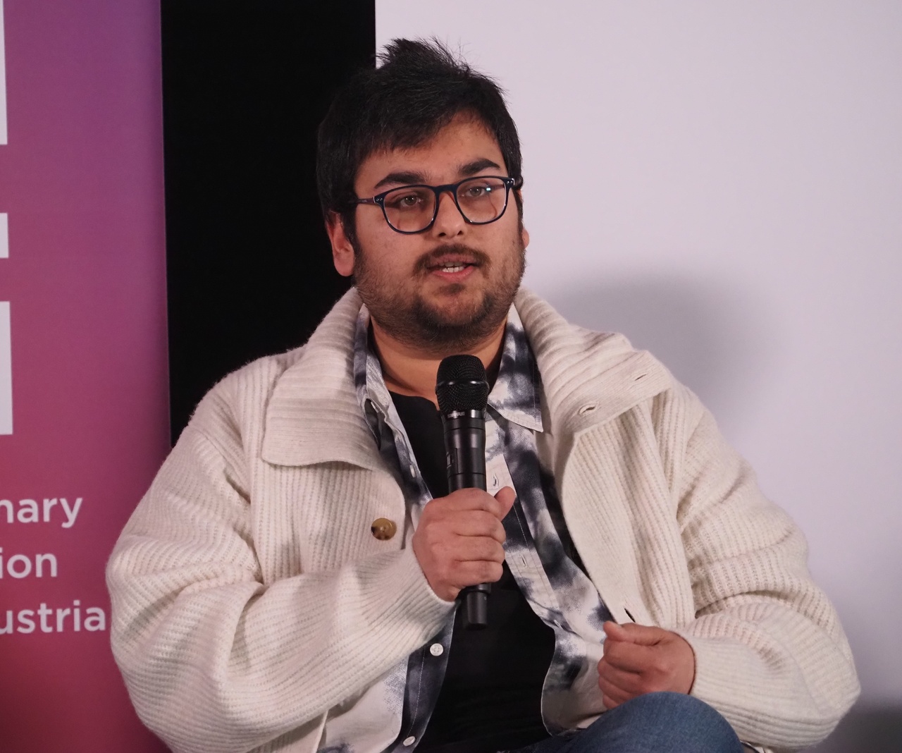Portrait of a person holding a microphone.