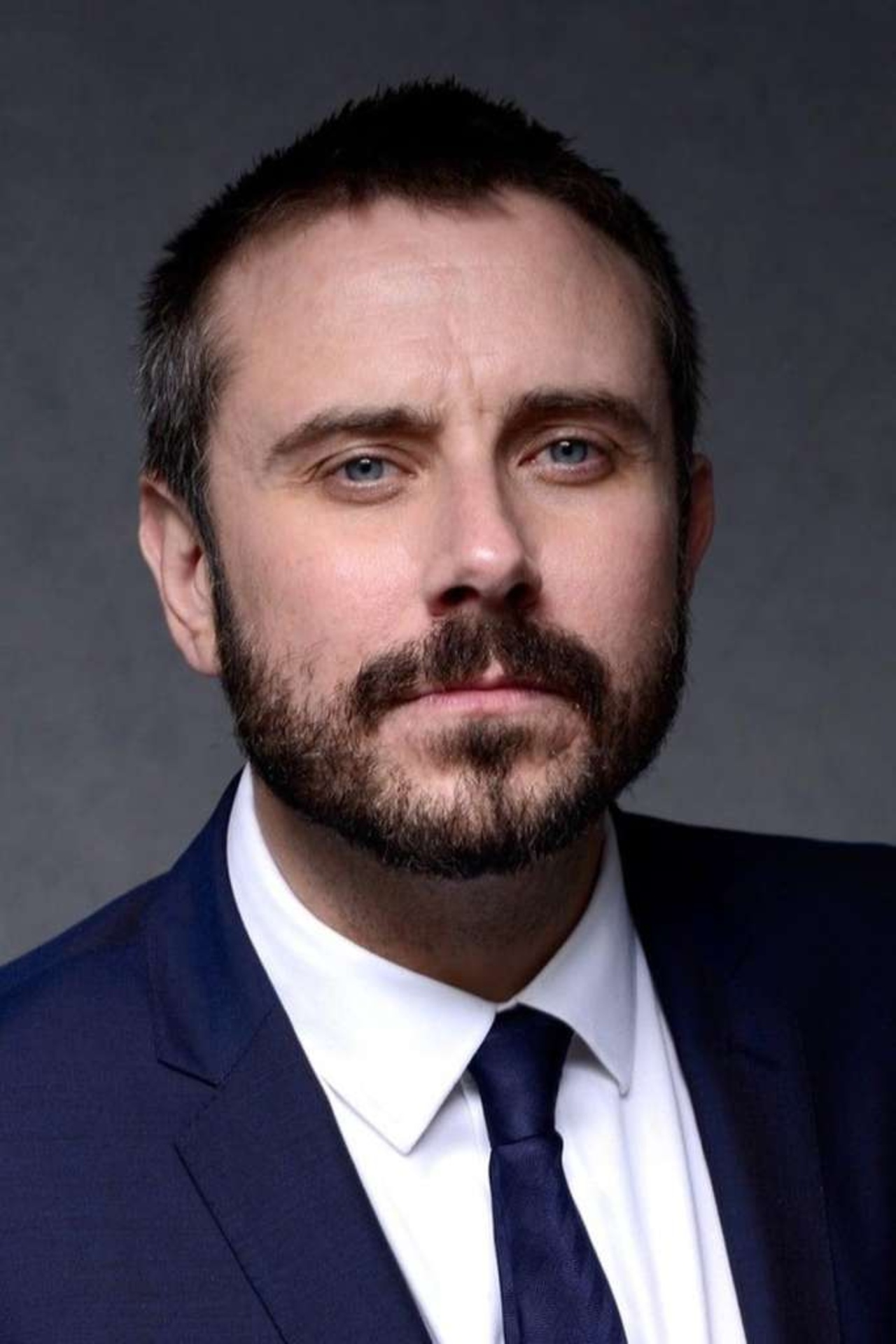 Portrait of a person in front of a grey background.