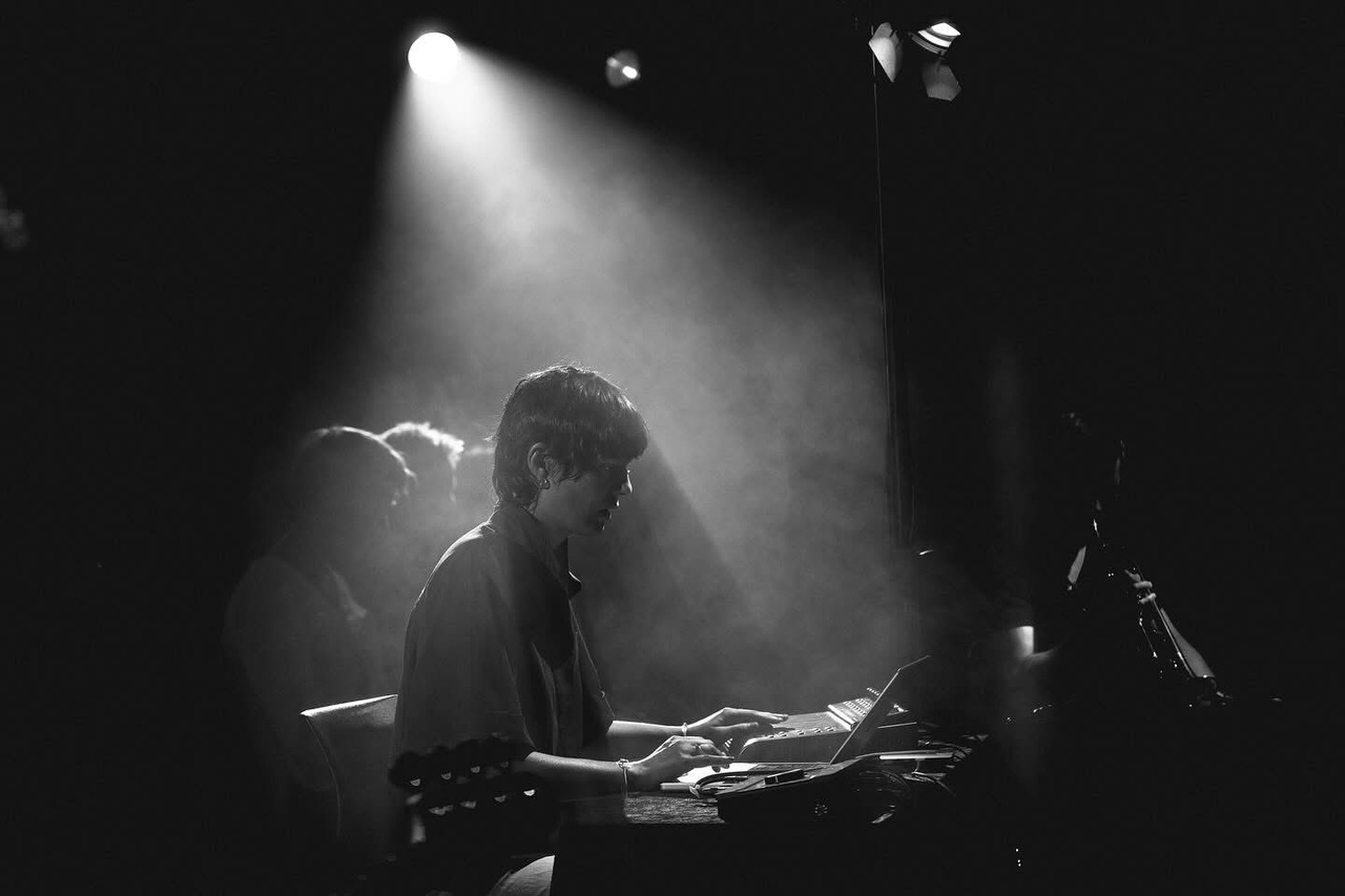 The portrait photo of a person in the beam of a stage lamp can be seen. 