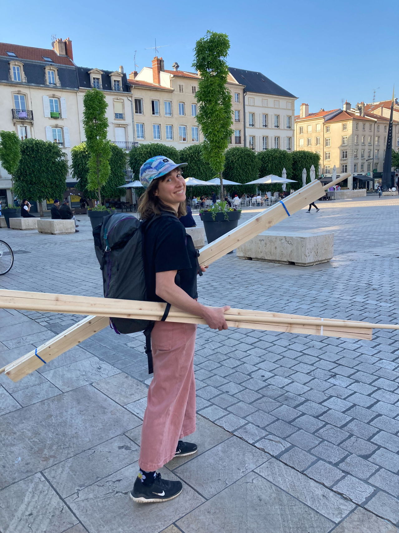 Katherine Ball carrying wooden planks to build a cloth sink and a graywater filtration system.