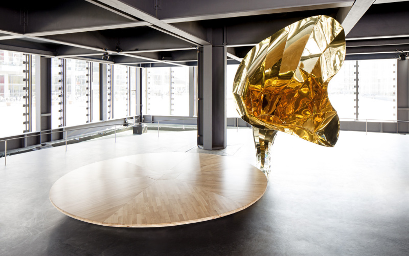 A golden gramophone horn at a large round wooden plate