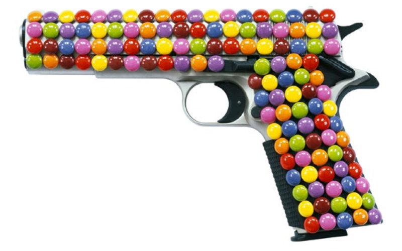 Eine Pistole ist ganz von Smarties umhüllt.