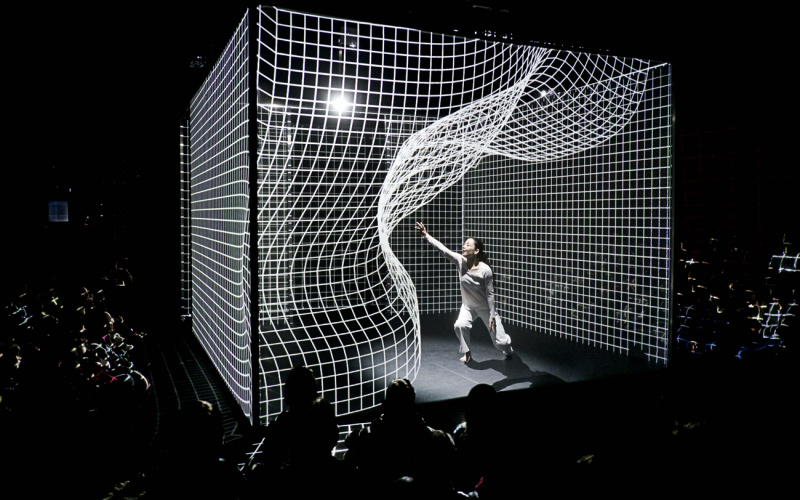 A person is dancing in the middle of an animated matrix