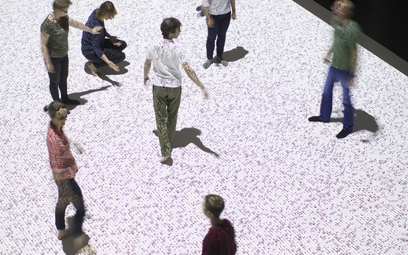 Tanzende Menschen auf einer Datenmatrix