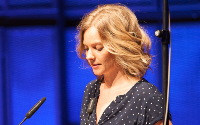 A woman standing at a table an reading something