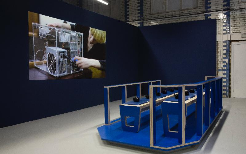 Blaue Sitzinstallation mit Kopfhörern vor einem Bildschirm